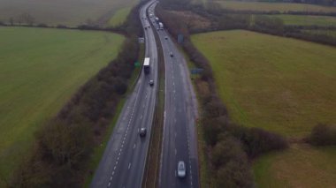 Trafik ve arabalarla dolu işlek otoyolun havadan görüntüsü, İngiltere 'de ulaşım ve seyahat için otoyollar.