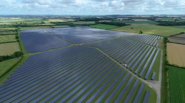 Büyük güneş paneli kurulumunun hava aracı görüntüsü. İngiliz kırsalındaki yenilenebilir kaynaklardan fotovoltaik elektrik santralleri. Güneşli bir yaz günü Birleşik Krallık.