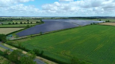 Büyük güneş paneli kurulumunun hava aracı görüntüsü. İngiliz kırsalındaki yenilenebilir kaynaklardan fotovoltaik elektrik santralleri. Güneşli bir yaz günü Birleşik Krallık.