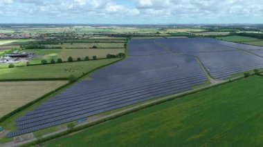 Büyük güneş paneli kurulumunun hava aracı görüntüsü. İngiliz kırsalındaki yenilenebilir kaynaklardan fotovoltaik elektrik santralleri. Güneşli bir yaz günü Birleşik Krallık.