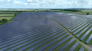 Büyük güneş paneli kurulumunun hava aracı görüntüsü. İngiliz kırsalındaki yenilenebilir kaynaklardan fotovoltaik elektrik santralleri. Güneşli bir yaz günü Birleşik Krallık.