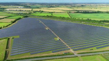 Büyük güneş paneli kurulumunun hava aracı görüntüsü. İngiliz kırsalındaki yenilenebilir kaynaklardan fotovoltaik elektrik santralleri. Güneşli bir yaz günü Birleşik Krallık.
