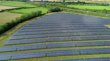 Büyük güneş paneli kurulumunun hava aracı görüntüsü. İngiliz kırsalındaki yenilenebilir kaynaklardan fotovoltaik elektrik santralleri. Güneşli bir yaz günü Birleşik Krallık.