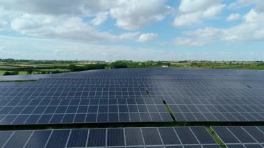 Büyük güneş paneli kurulumunun hava aracı görüntüsü. İngiliz kırsalındaki yenilenebilir kaynaklardan fotovoltaik elektrik santralleri. Güneşli bir yaz günü Birleşik Krallık.