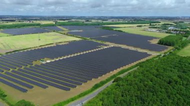 Büyük güneş paneli kurulumunun hava aracı görüntüsü. İngiliz kırsalındaki yenilenebilir kaynaklardan fotovoltaik elektrik santralleri. Güneşli bir yaz günü Birleşik Krallık.