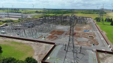 Keadby enerji santralinin hava aracı görüntüsü, pilonları ve kabloları olan elektrik alt istasyonu, yenilenebilir enerji kaynakları için rüzgar türbinleri. Yeşil kritik sanayi altyapısı, Keadby, Birleşik Krallık.