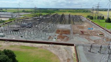 Keadby enerji santralinin hava aracı görüntüsü, pilonları ve kabloları olan elektrik alt istasyonu, yenilenebilir enerji kaynakları için rüzgar türbinleri. Yeşil kritik sanayi altyapısı, Keadby, Birleşik Krallık.