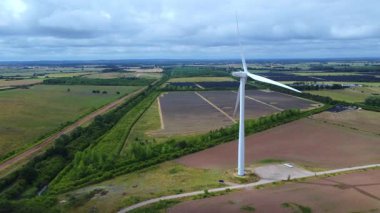 Devasa rüzgar türbini santralinin hava aracı görüntüsü, sürdürülebilir enerji ve yeşil kaynak altyapısı, gelecekteki elektrik tedarikleri için kritik endüstri. Birleşik Krallık 'ta küresel CO2 azaltımı ve net sıfır hedef.