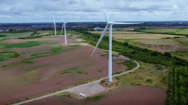 Devasa rüzgar türbini santralinin hava aracı görüntüsü, sürdürülebilir enerji ve yeşil kaynak altyapısı, gelecekteki elektrik tedarikleri için kritik endüstri. Birleşik Krallık 'ta küresel CO2 azaltımı ve net sıfır hedef.