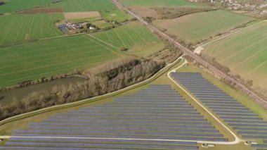 Büyük güneş paneli kurulumunun hava aracı görüntüsü. İngiliz kırsalındaki yenilenebilir kaynaklardan fotovoltaik elektrik santralleri. Güneşli bir yaz günü Birleşik Krallık.