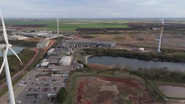 Endüstriyel arazi üzerindeki rüzgar türbinlerinin, depoların ve ticari faaliyet bölgesinin hava görüntüsü, Whittlesey, Peterborough, Birleşik Krallık 'ta sürdürülebilir yenilenebilir kaynaklar.
