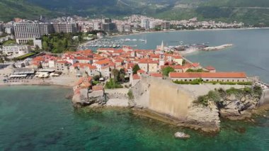 Budva 'nın eski kenti, Stari mezunu, terracotta çatısı ve şehir, dağ arkaplanı ve Karadağ' ın Avrupa manzarasının insansız hava aracı görüntüsü.