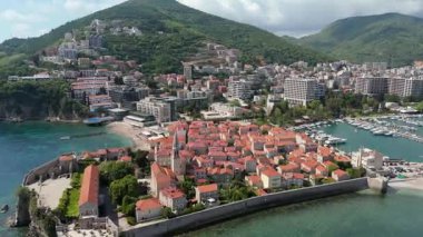 Budva 'nın eski kenti, Stari mezunu, terracotta çatısı ve şehir, dağ arkaplanı ve Karadağ' ın Avrupa manzarasının insansız hava aracı görüntüsü.