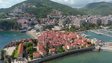 Budva 'nın eski kenti, Stari mezunu, terracotta çatısı ve şehir, dağ arkaplanı ve Karadağ' ın Avrupa manzarasının insansız hava aracı görüntüsü.