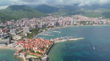Budva 'nın eski kenti, Stari mezunu, terracotta çatısı ve şehir, dağ arkaplanı ve Karadağ' ın Avrupa manzarasının insansız hava aracı görüntüsü.