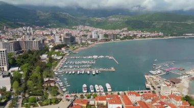 Budva 'nın eski kenti, Stari mezunu, terracotta çatısı ve şehir, dağ arkaplanı ve Karadağ' ın Avrupa manzarasının insansız hava aracı görüntüsü.