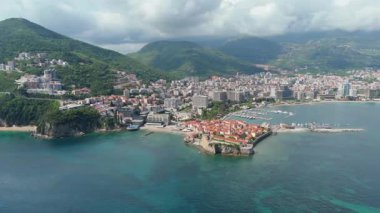 Budva 'nın eski kenti, Stari mezunu, terracotta çatısı ve şehir, dağ arkaplanı ve Karadağ' ın Avrupa manzarasının insansız hava aracı görüntüsü.