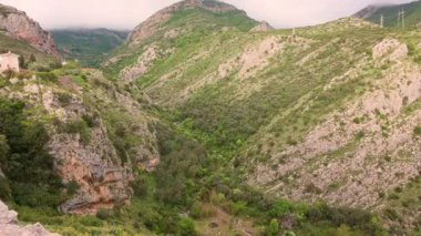 Karadağ 'ın Kotor kentindeki dev dağ sıralarının havadan görünüşü, yemyeşil bir manzara, baharda bulutlu bir zirve. Yollar rüzgarlı yılan şeritleri. Avrupa Seyahati.