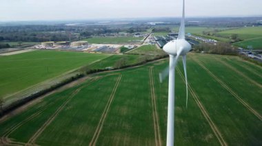 İngiltere 'de M1' de geniş rüzgar türbini dizisi ve yoğun otoyol trafiğinin hava aracı görüntüsü. Sürdürülebilir yenilenebilir enerji ve ulaşım temaları.