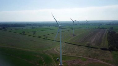 İngiltere 'de M1' de geniş rüzgar türbini dizisi ve yoğun otoyol trafiğinin hava aracı görüntüsü. Sürdürülebilir yenilenebilir enerji ve ulaşım temaları.