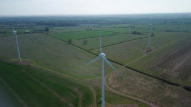 İngiltere 'de M1' de geniş rüzgar türbini dizisi ve yoğun otoyol trafiğinin hava aracı görüntüsü. Sürdürülebilir yenilenebilir enerji ve ulaşım temaları.