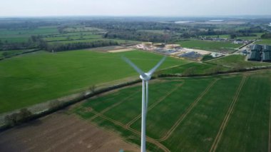 İngiltere 'de M1' de geniş rüzgar türbini dizisi ve yoğun otoyol trafiğinin hava aracı görüntüsü. Sürdürülebilir yenilenebilir enerji ve ulaşım temaları.