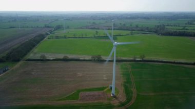 İngiltere 'de M1' de geniş rüzgar türbini dizisi ve yoğun otoyol trafiğinin hava aracı görüntüsü. Sürdürülebilir yenilenebilir enerji ve ulaşım temaları.