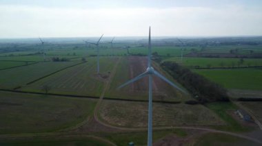 İngiltere 'de M1' de geniş rüzgar türbini dizisi ve yoğun otoyol trafiğinin hava aracı görüntüsü. Sürdürülebilir yenilenebilir enerji ve ulaşım temaları.