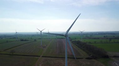 İngiltere 'de M1' de geniş rüzgar türbini dizisi ve yoğun otoyol trafiğinin hava aracı görüntüsü. Sürdürülebilir yenilenebilir enerji ve ulaşım temaları.