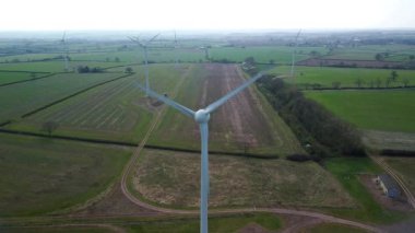 İngiltere 'de M1' de geniş rüzgar türbini dizisi ve yoğun otoyol trafiğinin hava aracı görüntüsü. Sürdürülebilir yenilenebilir enerji ve ulaşım temaları.