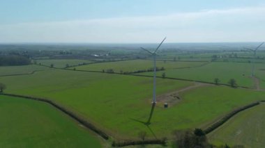 İngiltere 'de M1' de geniş rüzgar türbini dizisi ve yoğun otoyol trafiğinin hava aracı görüntüsü. Sürdürülebilir yenilenebilir enerji ve ulaşım temaları.