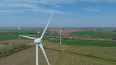 İngiltere 'de M1' de geniş rüzgar türbini dizisi ve yoğun otoyol trafiğinin hava aracı görüntüsü. Sürdürülebilir yenilenebilir enerji ve ulaşım temaları.