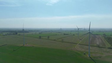 İngiltere 'de M1' de geniş rüzgar türbini dizisi ve yoğun otoyol trafiğinin hava aracı görüntüsü. Sürdürülebilir yenilenebilir enerji ve ulaşım temaları.