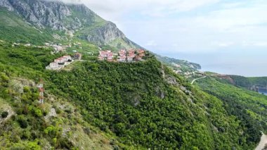 Karadağ 'ın Kotor kentindeki dev dağ sıralarının havadan görünüşü, yemyeşil bir manzara, baharda bulutlu bir zirve. Yollar rüzgarlı yılan şeritleri. Avrupa Seyahati.