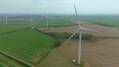 Devasa rüzgar türbini santralinin hava aracı görüntüsü, sürdürülebilir enerji ve yeşil kaynak altyapısı, gelecekteki elektrik tedarikleri için kritik endüstri. Birleşik Krallık 'ta küresel CO2 azaltımı ve net sıfır hedef.
