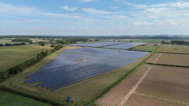 İngiltere 'deki devasa bir güneş enerjisi dizisinin yukarıdan aşağıya hava aracı görüntüsü Ulusal Şebeke güncellemesi için yenilenebilir fotovoltaik enerji üretiyor.
