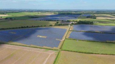 İngiltere 'deki devasa bir güneş enerjisi dizisinin yukarıdan aşağıya hava aracı görüntüsü Ulusal Şebeke güncellemesi için yenilenebilir fotovoltaik enerji üretiyor.