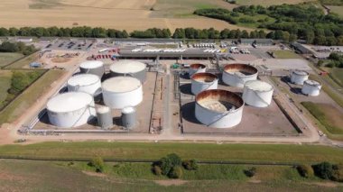 Devasa yakıt deposu, silolar ve petrol deposu LPG gazı ve gazyağı tankları, güneşli yaz günü, enerji ve altyapı İngiltere