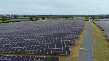 İngiltere 'deki devasa bir güneş enerjisi dizisinin yukarıdan aşağıya hava aracı görüntüsü Ulusal Şebeke güncellemesi için yenilenebilir fotovoltaik enerji üretiyor.