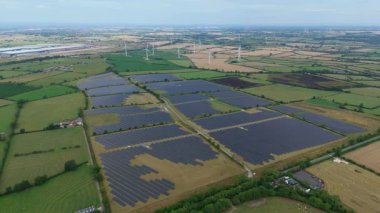 İngiltere 'deki devasa bir güneş enerjisi dizisinin yukarıdan aşağıya hava aracı görüntüsü Ulusal Şebeke güncellemesi için yenilenebilir fotovoltaik enerji üretiyor.