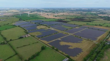 İngiltere 'deki devasa bir güneş enerjisi dizisinin yukarıdan aşağıya hava aracı görüntüsü Ulusal Şebeke güncellemesi için yenilenebilir fotovoltaik enerji üretiyor.