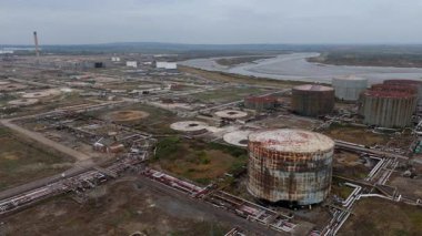 İngiltere Canvey Adası 'ndaki paslanmış endüstriyel tanklar ve terk edilmiş altyapıya sahip büyük petrol ve yakıt deposunun insansız hava aracı görüntüsü.