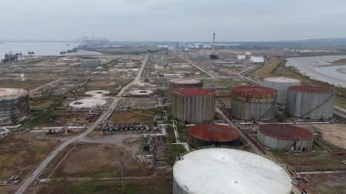 İngiltere Canvey Adası 'ndaki paslanmış endüstriyel tanklar ve terk edilmiş altyapıya sahip büyük petrol ve yakıt deposunun insansız hava aracı görüntüsü.