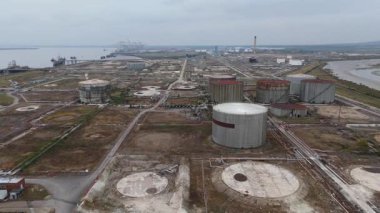 İngiltere Canvey Adası 'ndaki paslanmış endüstriyel tanklar ve terk edilmiş altyapıya sahip büyük petrol ve yakıt deposunun insansız hava aracı görüntüsü.