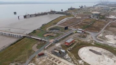 İngiltere Canvey Adası 'ndaki paslanmış endüstriyel tanklar ve terk edilmiş altyapıya sahip büyük petrol ve yakıt deposunun insansız hava aracı görüntüsü.