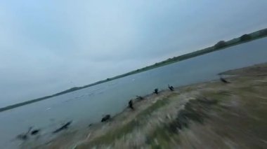 FPV insansız hava aracı Rutland İngiltere 'de yemyeşil sulak arazi ve Göz Brooke rezervuarı bulutlu bulutlu gün üzerinden geçiyor.