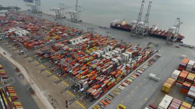 Bir sürü yük konteynırı ve büyük kargo gemisi kenetlenmiş büyük bir nakliye limanının insansız hava aracı görüntüsü, Gri trenler ve ithalat için malları taşıyan HGV 'ler, Londra Thames UK kapısı.