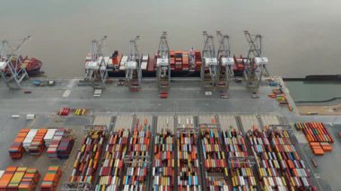 Bir sürü yük konteynırı ve büyük kargo gemisi kenetlenmiş büyük bir nakliye limanının insansız hava aracı görüntüsü, Gri trenler ve ithalat için malları taşıyan HGV 'ler, Londra Thames UK kapısı.