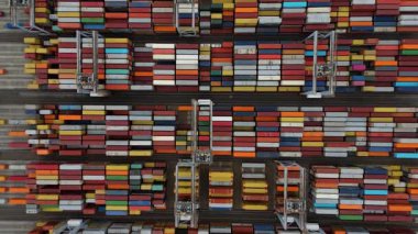 Bir sürü yük konteynırı ve büyük kargo gemisi kenetlenmiş büyük bir nakliye limanının insansız hava aracı görüntüsü, Gri trenler ve ithalat için malları taşıyan HGV 'ler, Londra Thames UK kapısı.