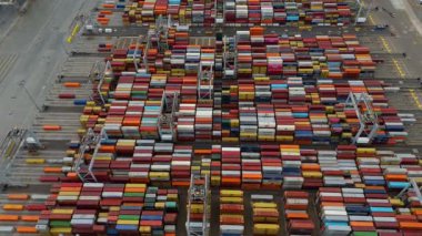 Bir sürü yük konteynırı ve büyük kargo gemisi kenetlenmiş büyük bir nakliye limanının insansız hava aracı görüntüsü, Gri trenler ve ithalat için malları taşıyan HGV 'ler, Londra Thames UK kapısı.